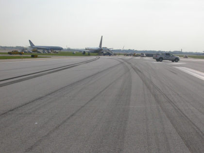 Photo 02. Skid Marks Leading Off the Side of Runway 22R.