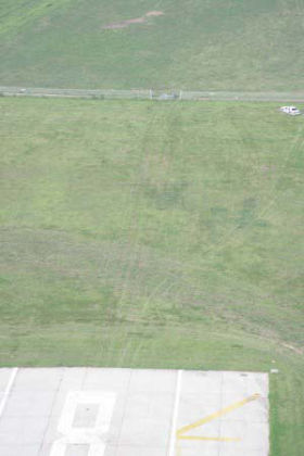 Photo 5. Aerial photo of the end of runway 26 and the damaged airport perimeter fence
