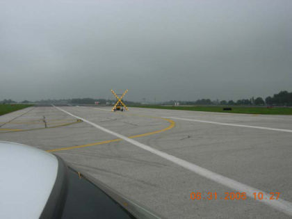 Photo 34. Runway 26 with the runway 4/22 intersection sign, lead-off line, white edge