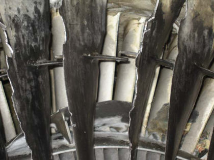 PHOTO 19: HARD BODY DAMAGE AND FAN BLADE FRAGMENT RESTING IN FRONT OF THE OGVS