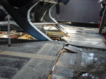 Photo 36. Similar view of the damage beneath seat 22E with baggage and carpet removed