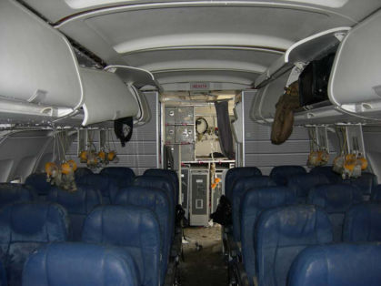 Photo 40. Aft cabin and galley (Note: “direct view” jumpseat had been stowed by investigators prior to this picture)