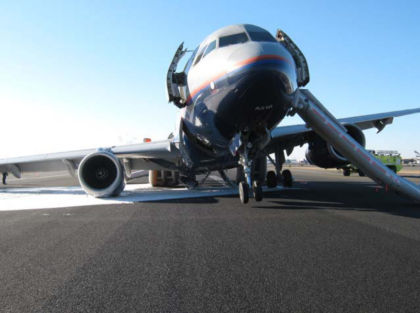 1. View of N816UA on the tarmac at EWR (Provided by United Airlines) Note: The airplane’s nose wheel is off the ground and its right (number 2) engine is resting on the tarmac. Also, note the fully opened 1L door and its deployed evacuation