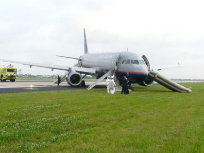 2. Photograph looking at the right side of N409UA. Note: The 1R slide/raft is hanging limp at the 1R exit, and an ARFF ladder is placed at the exit
