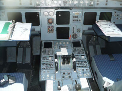 Figure 5. Cockpit, as found. The two vertically oriented Engine Centralized Aircraft Monitoring (ECAM) displays are in the center. All cockpit oxygen masks were found stowed. Both engine fire handles were found in the pulled state. When ele