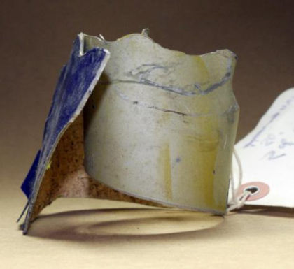 Figure 68: Skin material The paint on the side of the skin material opposite the blue colored paint was tan in color. The tan paint was not flaking. A fairly thin, even coating of dirt had collected on the tan colored surface; see Figure 69