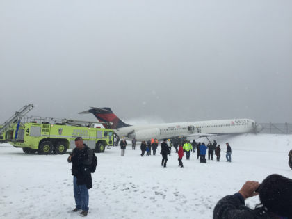 PHOTOGRAPH 5 - Passengers are on tarmac in the snow. A fire truck are positioned aft