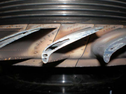 Photo 11: Close up of 1st stage turbine blade tips showing rub into internal cavity The 1st stage turbine blade front retaining plate was in place on the disk. The 1st stage turbine blade front retaining plate had numerous circumferential s