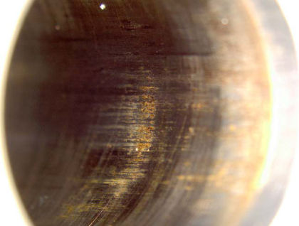 Photo No. 9: Close up view of FMV sleeve showing brown substance with axial scratches. — page 23 of 41