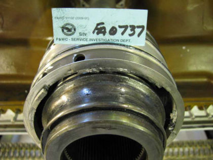 Figure 33. No. 1 bearing split inner race and oil nozzle housing retaining ring The ring that retains the No. 1 bearing oil nozzle housing to the bearing inner race was present but was fractured, and several retaining ring lugs and small pi