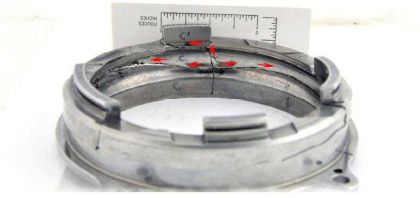 Figure 39. Bearing outer race rotated 180° clockwise showing origin and direction of fatigue crack propagation (red arrows)