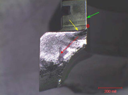 Figure 41. Magnified view of origin area showing the fatigue crack propagating from the upper section of the radius at the intersection of the large lug (green arrow) and the end face of the outer race (yellow arrow). Red arrow denotes the 