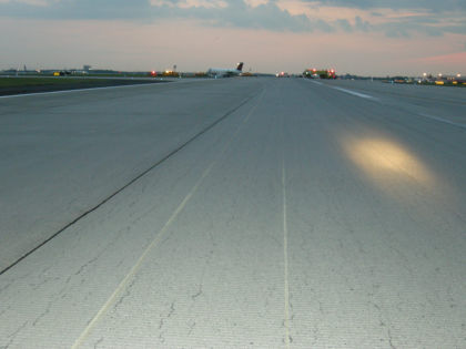 Photo 1: Runway Scars with N857AS in Background (NTSB Digital Photo)