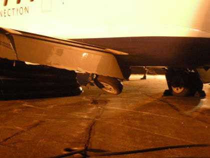 Photo 6: Left Main Landing Gear as Aircraft is Raised with Air Bags (NTSB Digital Photo)