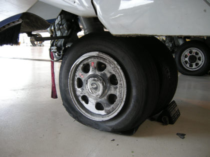Photo 8: Damage to Left Main Outboard Tire and Wheel (NTSB Digital Photo)
