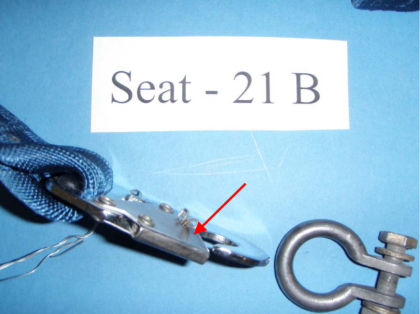2. Close up of seat 21B restraint with a red arrow pointing to it’s bent keeper