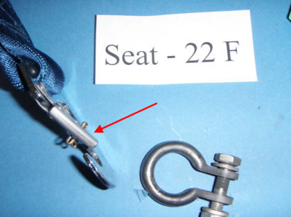 4. Close up view of restraint from seat 22F. Note: Red arrow points to the bent keeper and the cotter pin through the keeper and hook