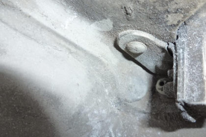 Figure 8: a) Photograph of the fractured lower stop outboard bracket on N369AT; b) Photograph showing deformation to the shim stack resting on the support flange and a gap (left)
