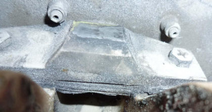 Figure 8: a) Photograph of the fractured lower stop outboard bracket on N369AT; b) Photograph showing deformation to the shim stack resting on the support flange and a gap (right)