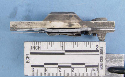 Figure 9: Lower stop, shim stack, and fractured outboard bracket from N369AT; a) Overview (left)