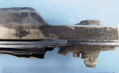 Figure 9: Lower stop, shim stack, and fractured outboard bracket from N369AT; a) Overview (right)