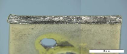 Figure 19: The fracture surface on the lower stop bracket from N260AE. Fatigue cracks were observed initiating at the outer